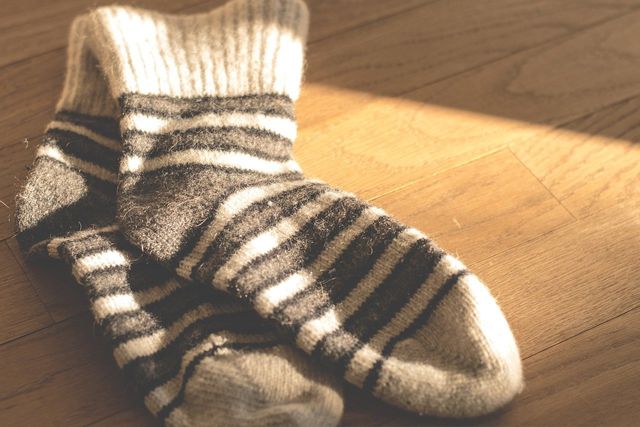 One way to keep warm without electricity is to layer up, like wearing wool socks in the house.