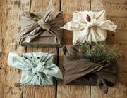 Four square gifts wrapped in fabric and tied with decorative knots.