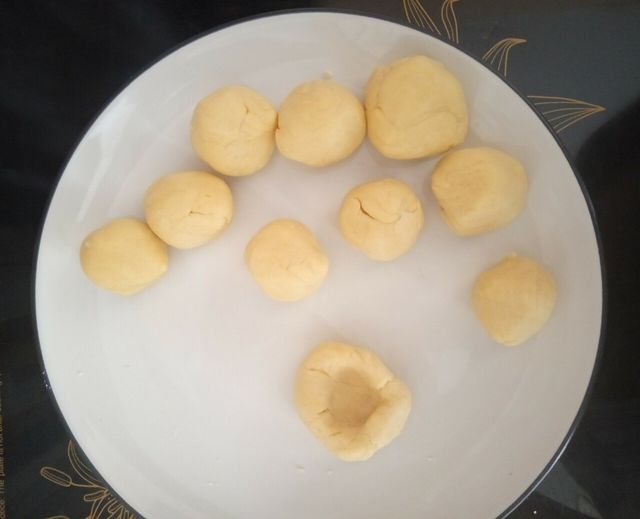 Roll the pieces of dough into balls and make a bowl shape in the center.