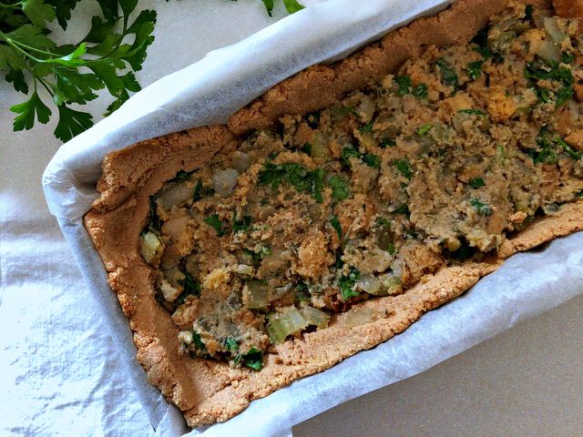 Use a spatula to help you spread the tofu mixture in the loaf pan before you add the stuffing to your vegan turkey.
